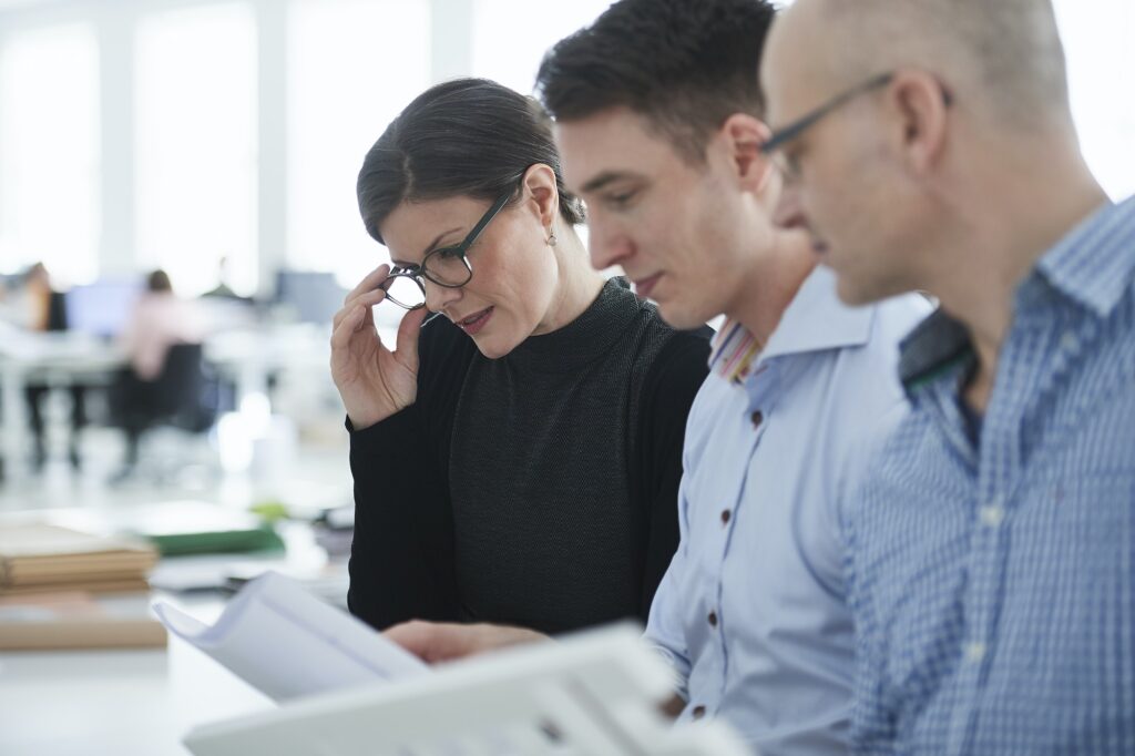 Colleagues in office looking at architectural model